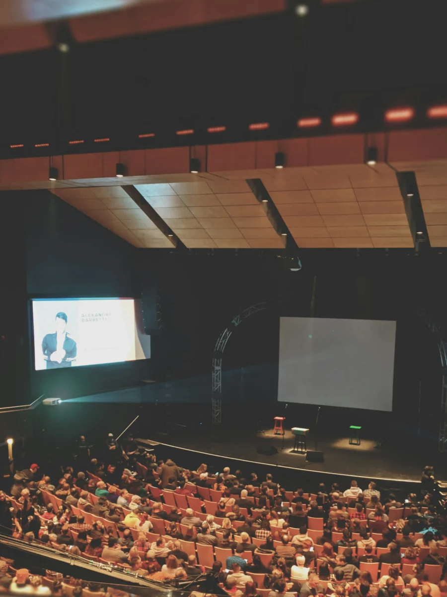 Public rassemblé dans une salle de conférence
