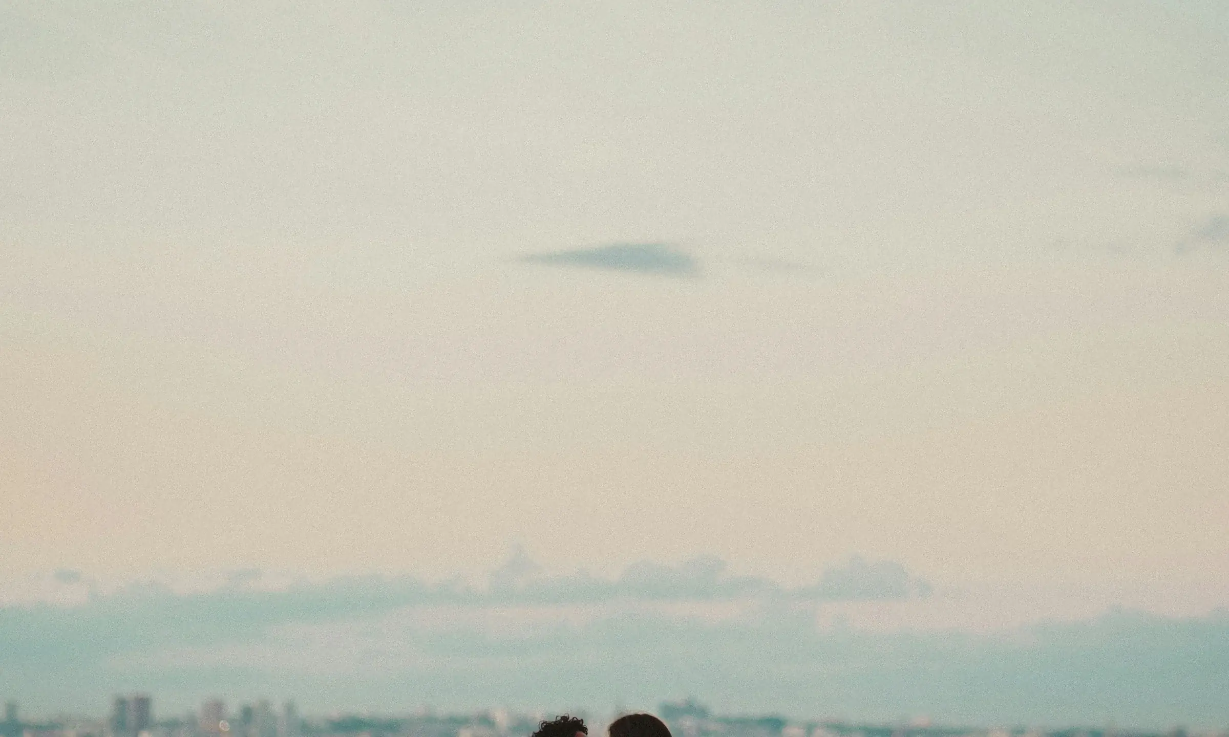 Un couple s’embrasse sur un parapet dominant la ville