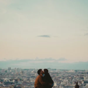 Un couple s’embrasse sur un parapet dominant la ville