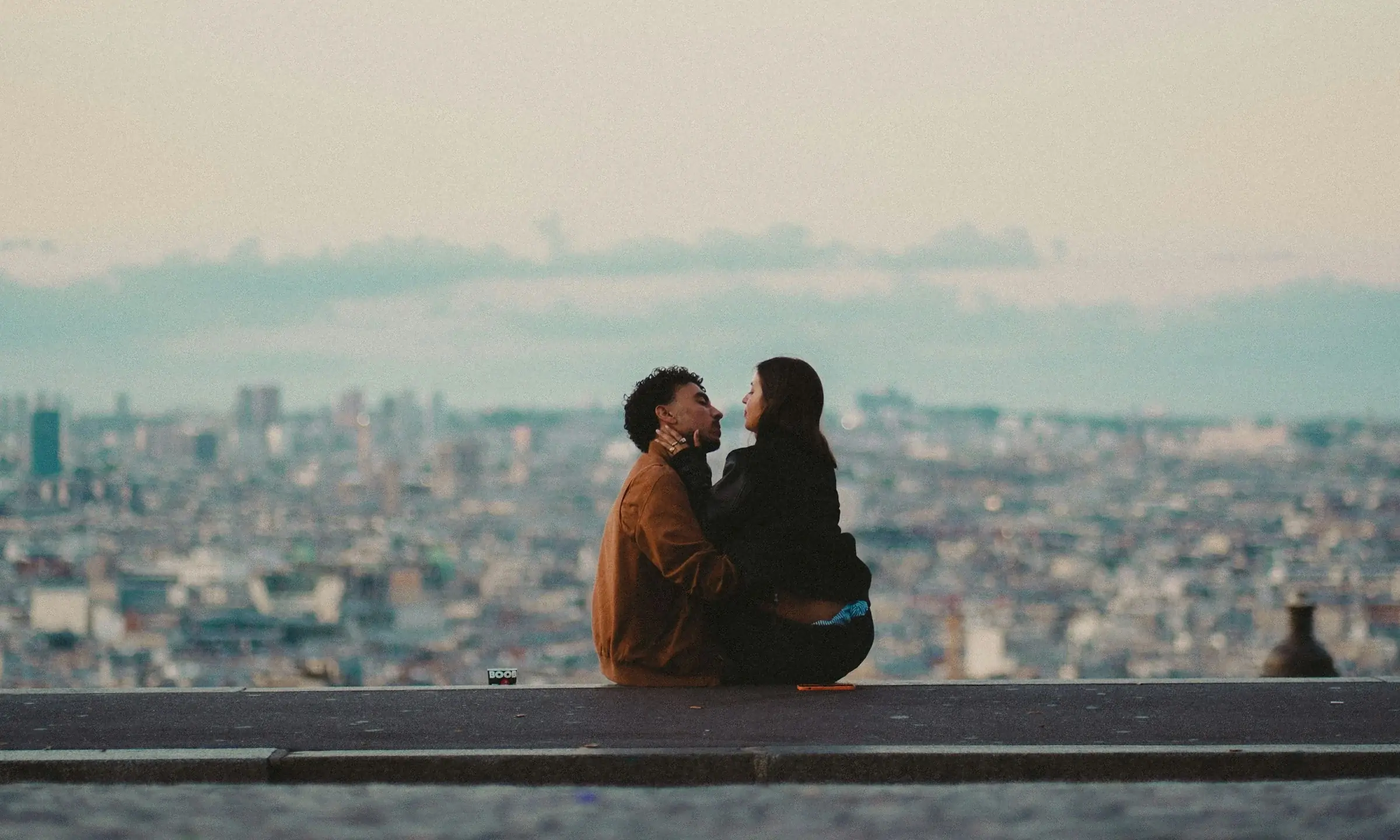 Un couple assis face aux toits de la ville