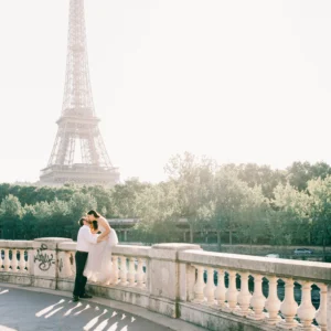 Couple s’embrassant sur un pont, tour Eiffel en arrière-plan