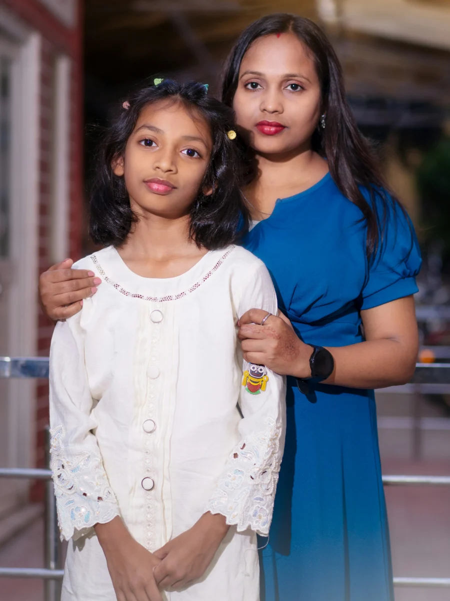 Une mère et sa fille regardent l’objectif