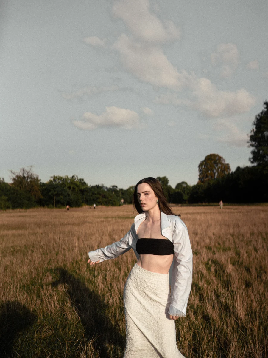 Mujer caminando por un campo con vestido blanco