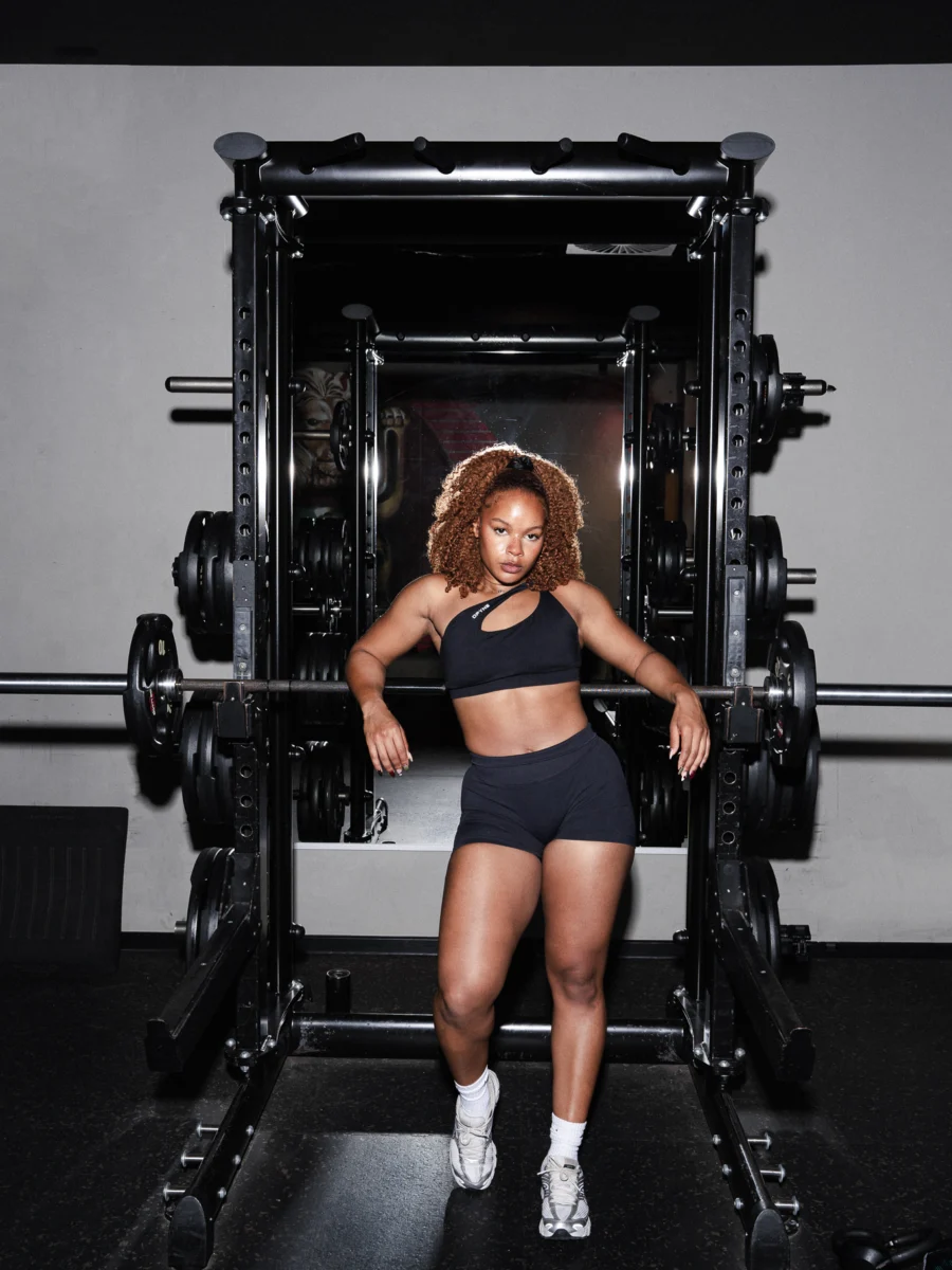 Femme soulevant une barre de musculation en salle de sport