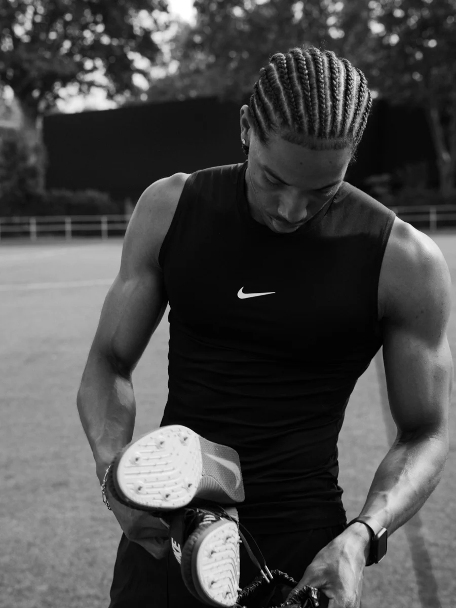 Footballeur tenant ses crampons sur le terrain
