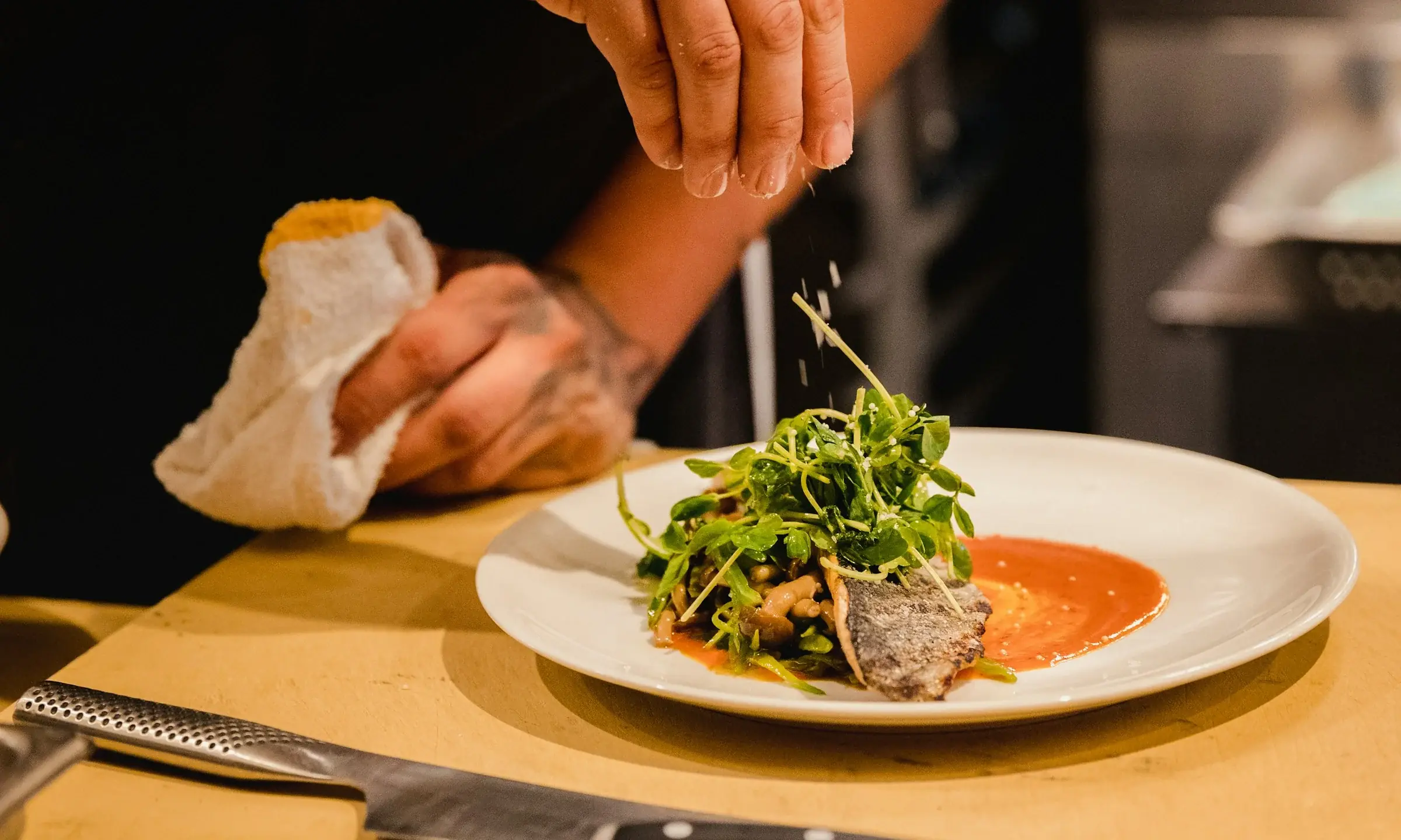 Un chef dresse une assiette de légumes