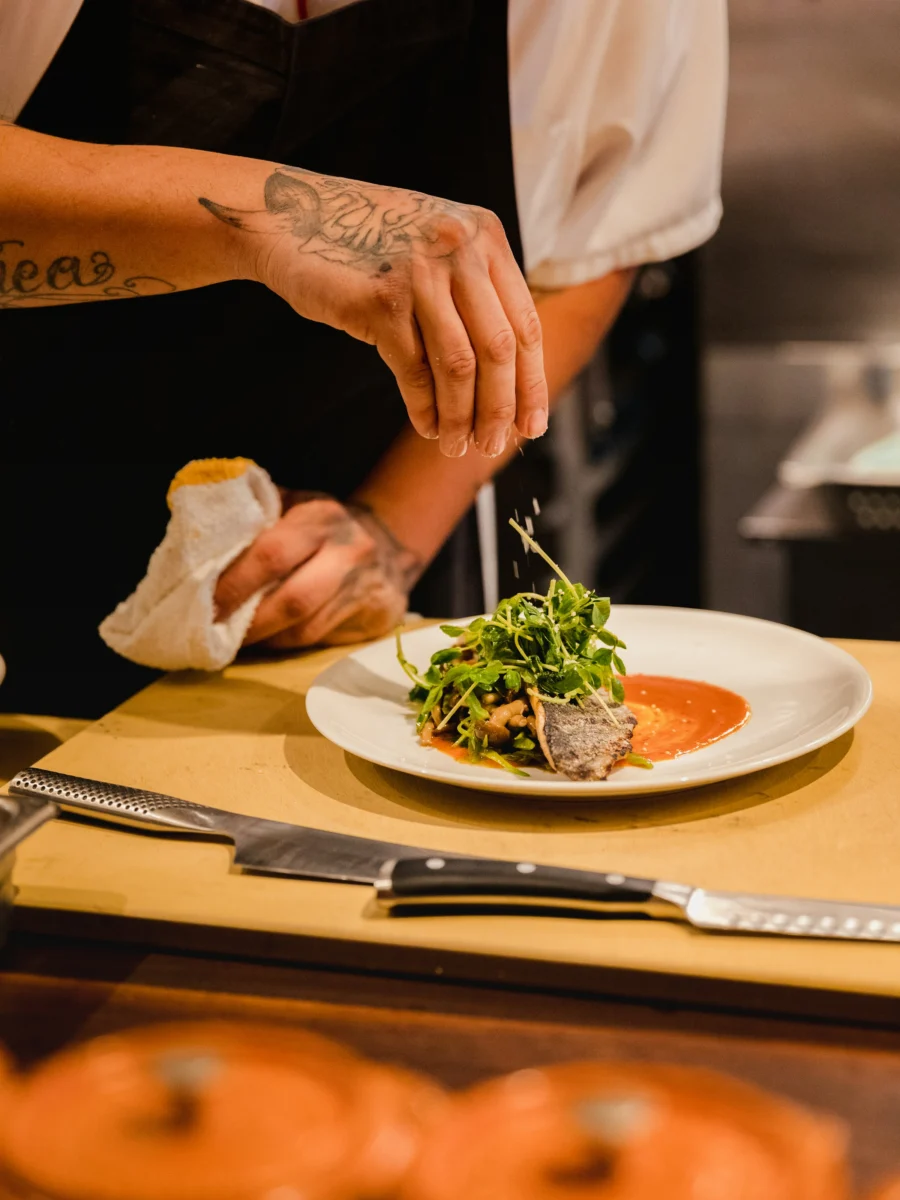 Un chef dresse une assiette de légumes