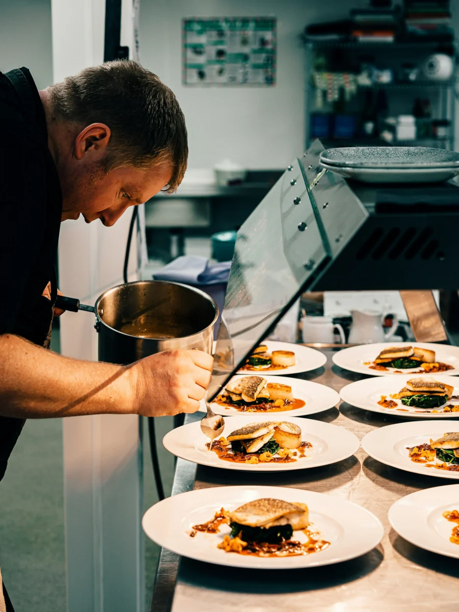 Un cuisinier tient un bol en inox en cuisine