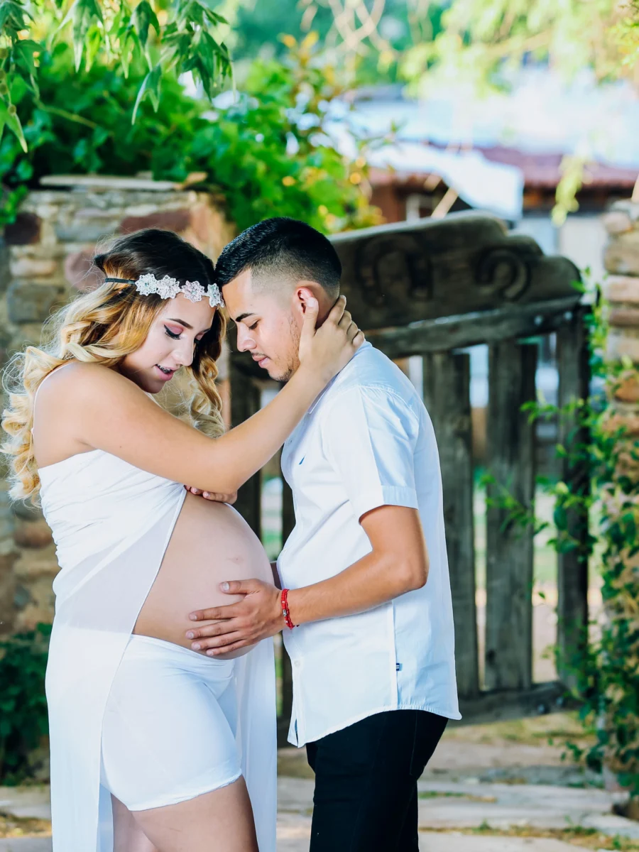 Couple enceinte s’enlaçant dans un jardin