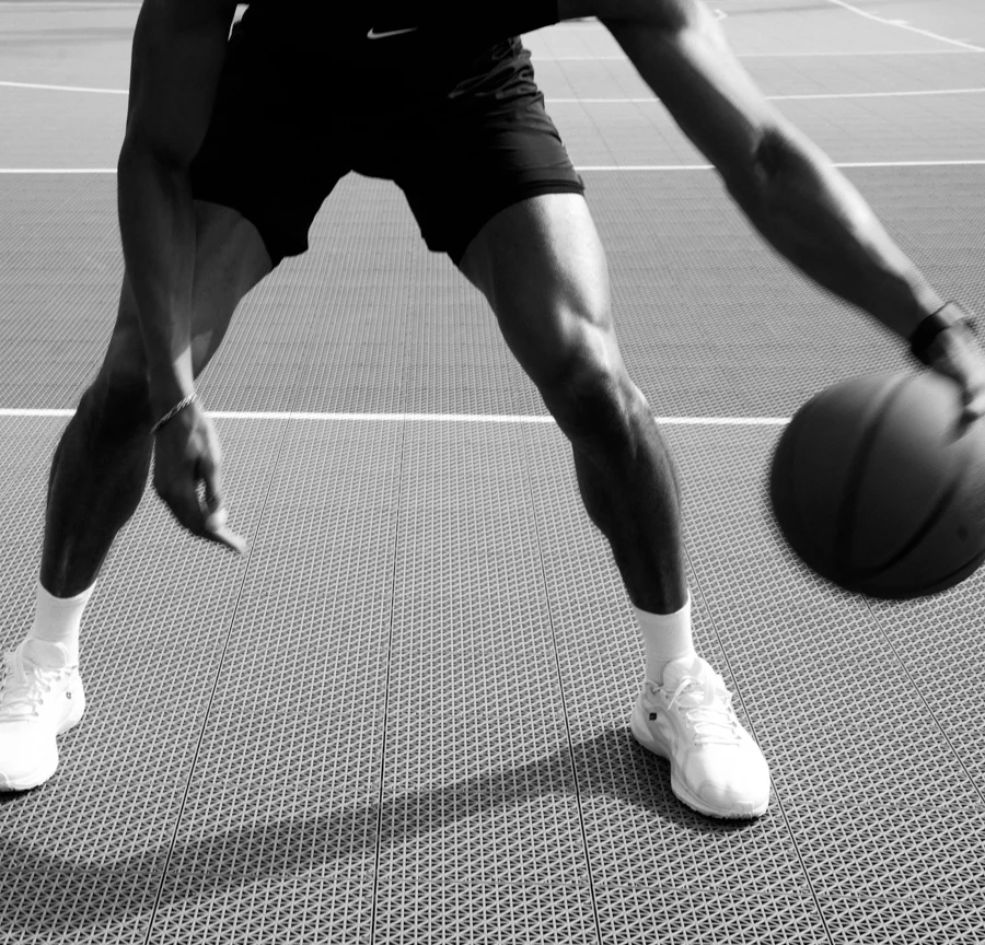 Homme dribblant un ballon de basket, noir et blanc
