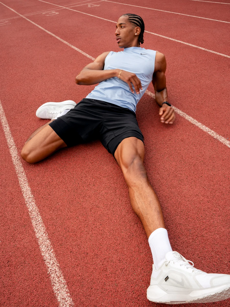 A man stretching on an athletics track