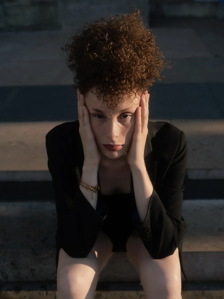 Portrait assis sur des marches, mains sur le visage