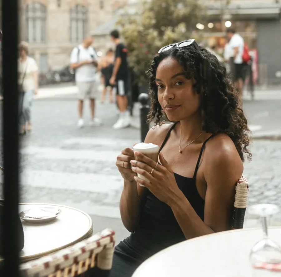 Retrato en la terraza de un café de Montmartre, joven con un café mirando a la cámara