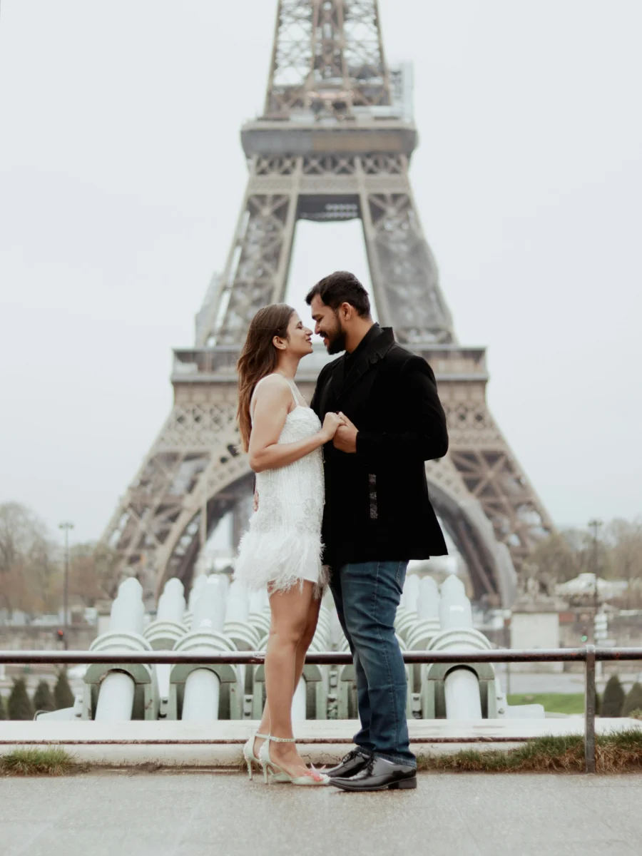 Un couple enlacé devant la tour Eiffel
