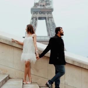 Un couple se tient la main près de la tour Eiffel