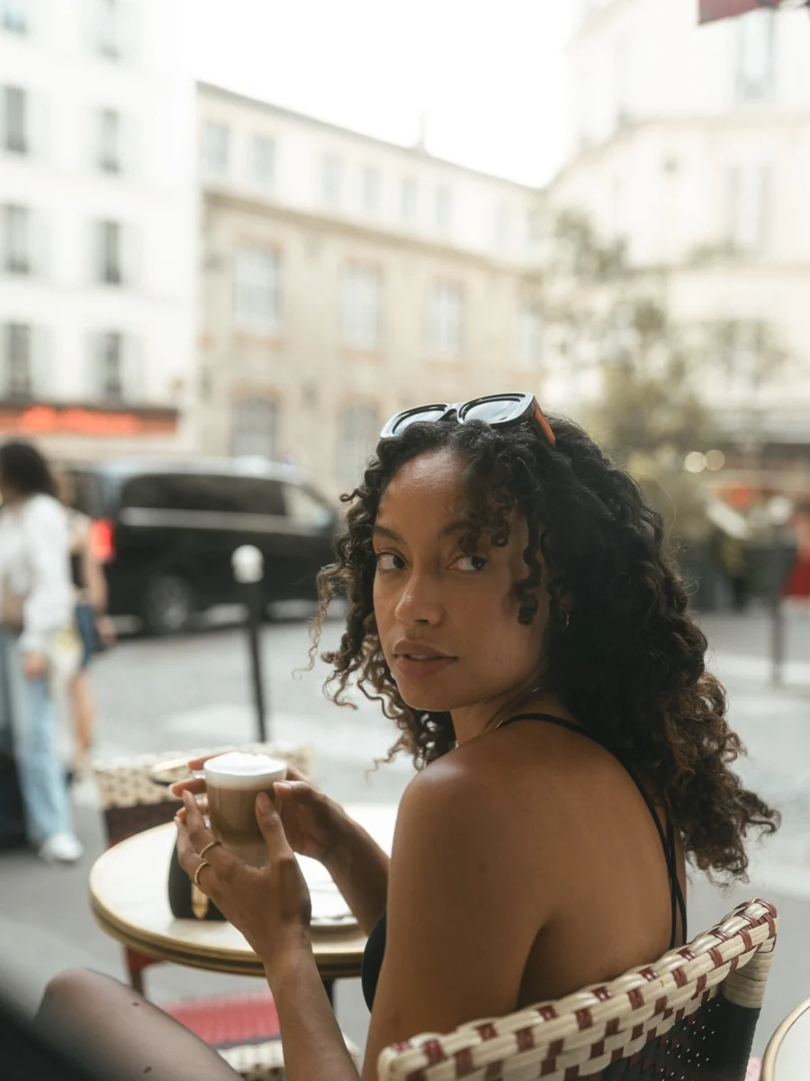 Portrait de profil à la terrasse d'un café à Montmartre, lunettes de soleil posées sur la tête