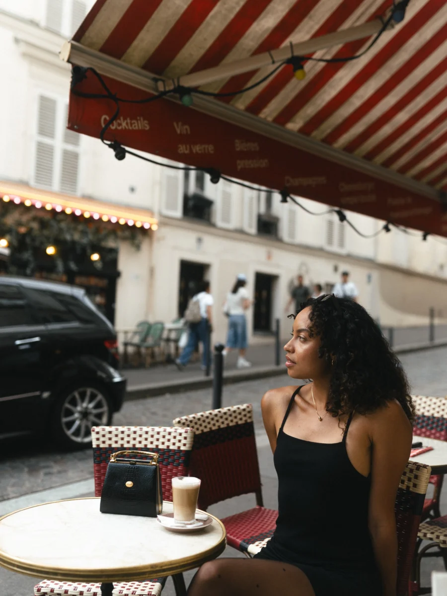 Portrait sous l'auvent d'un café à Montmartre, rue pavée en arrière-plan