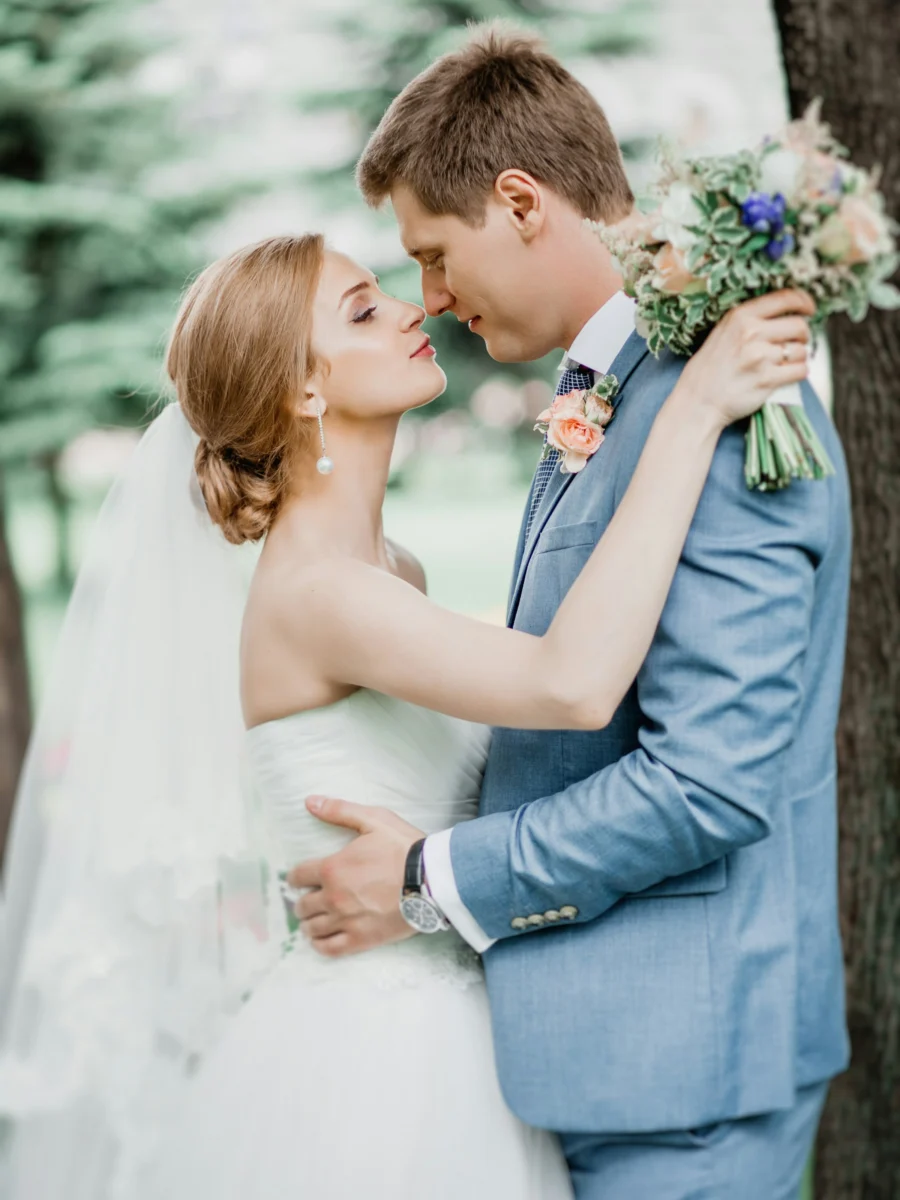 Un marié en costume gris embrasse la mariée