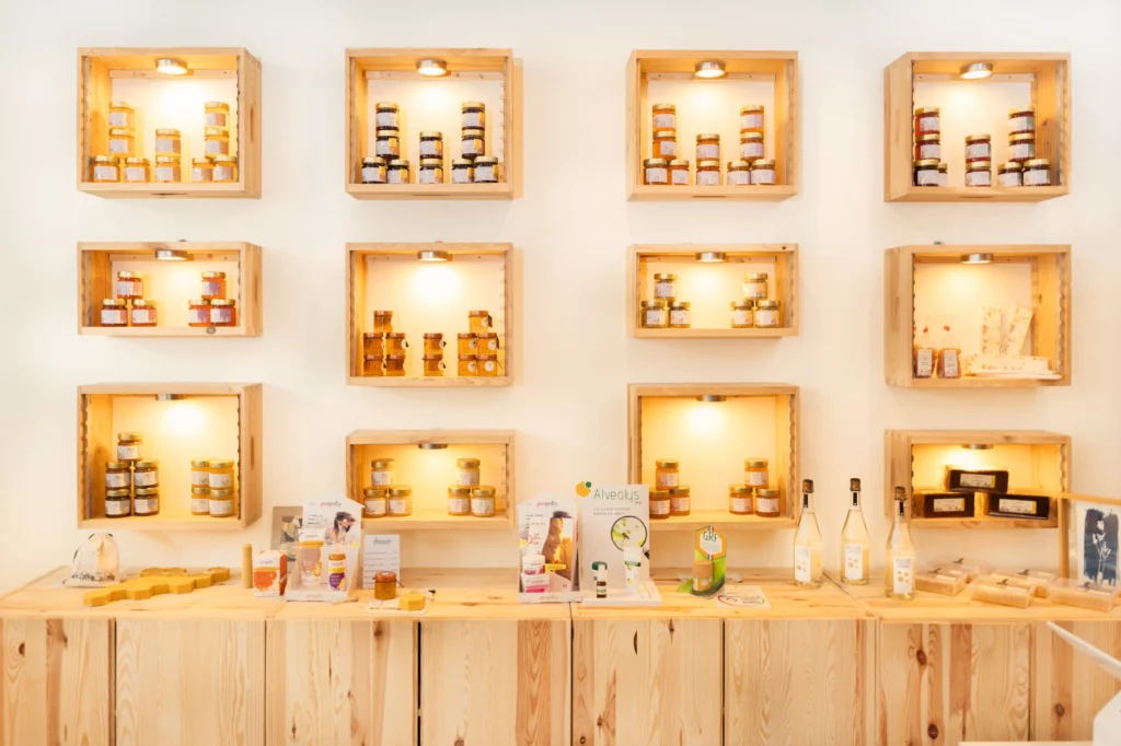 Étagères en bois éclairées avec des pots de miel dans la boutique CityBzz, Paris 13e