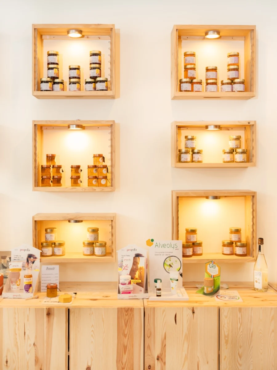 Étagères en bois éclairées avec des pots de miel dans la boutique CityBzz, Paris 13e