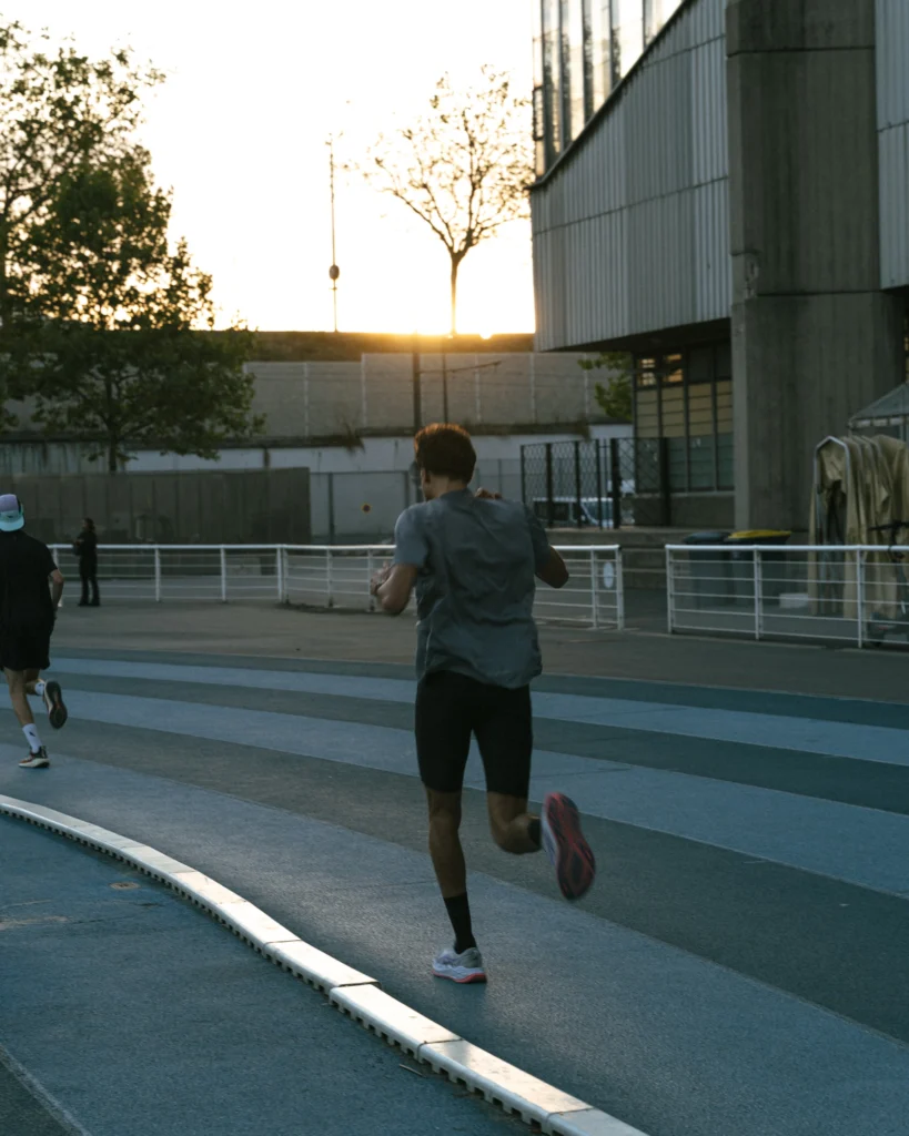 Coureur photographié de dos sur la piste en fin de journée