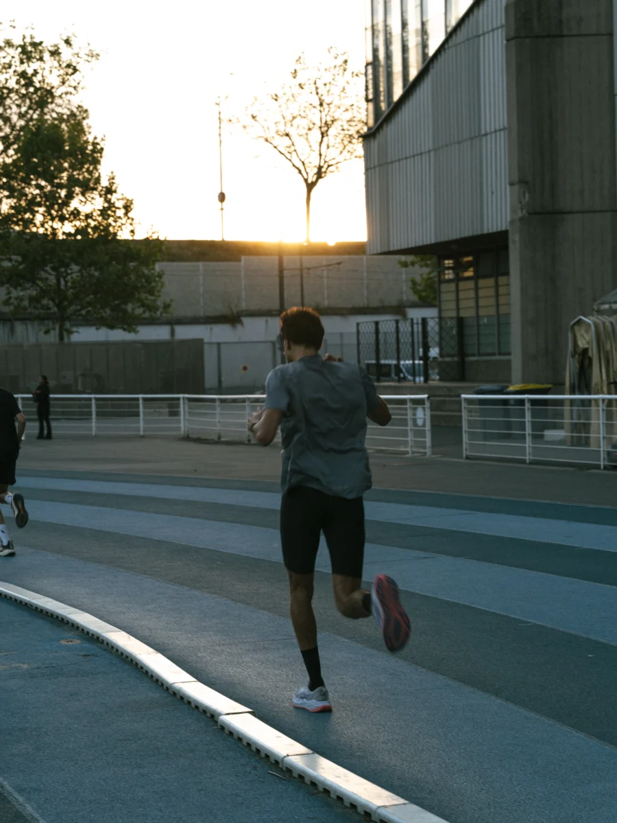 Coureur photographié de dos sur la piste en fin de journée