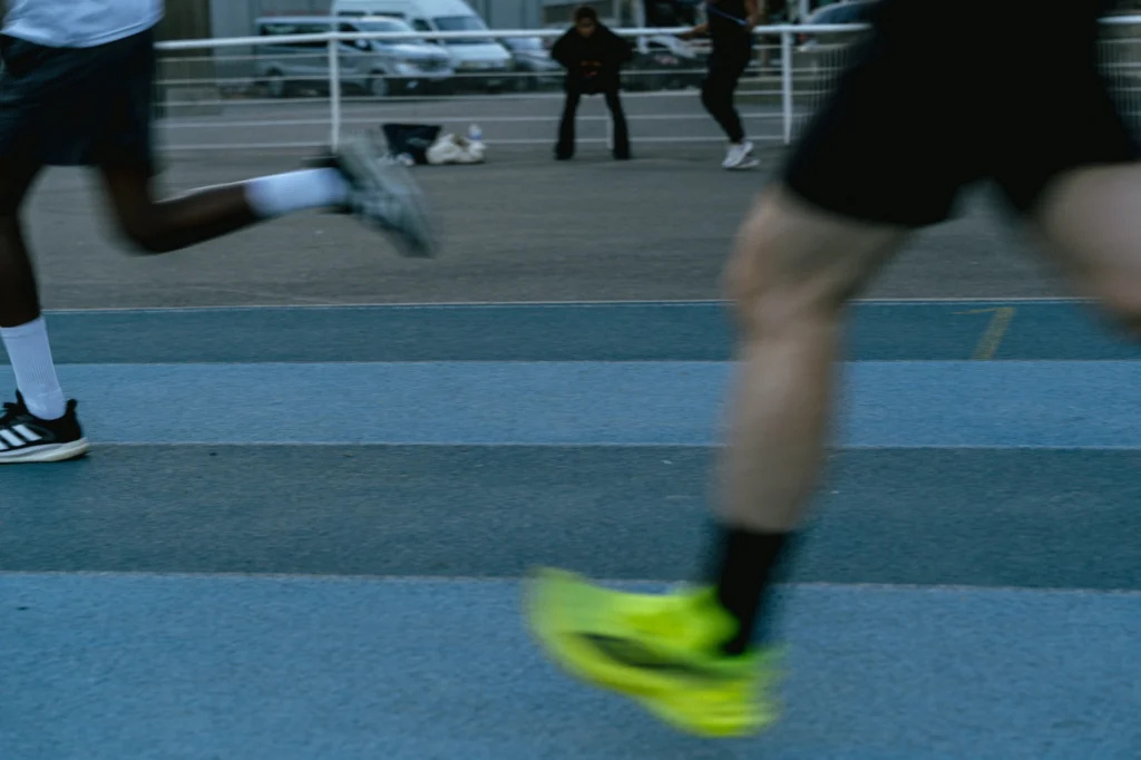 Jambes de deux coureurs en mouvement sur une piste bleue