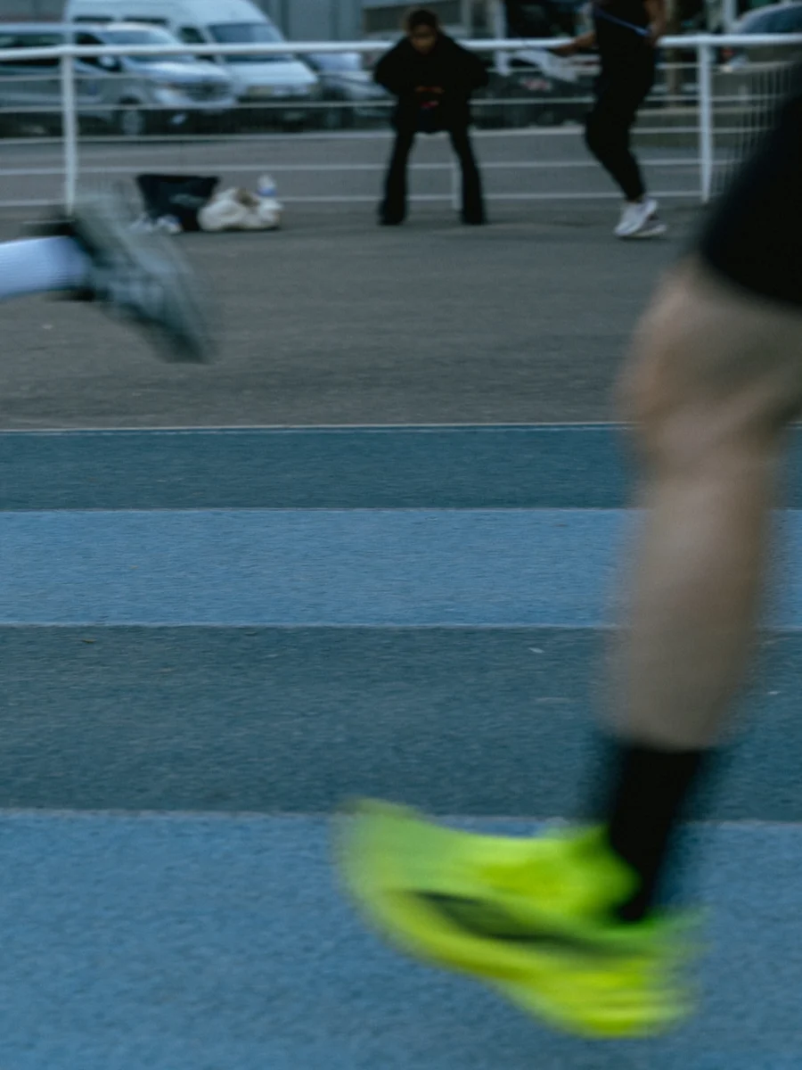 Jambes de deux coureurs en mouvement sur une piste bleue