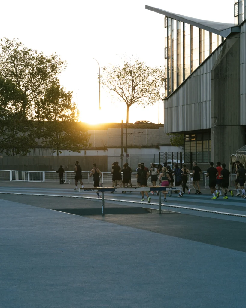 Groupe de coureurs sur une piste d’athlétisme au coucher du soleil