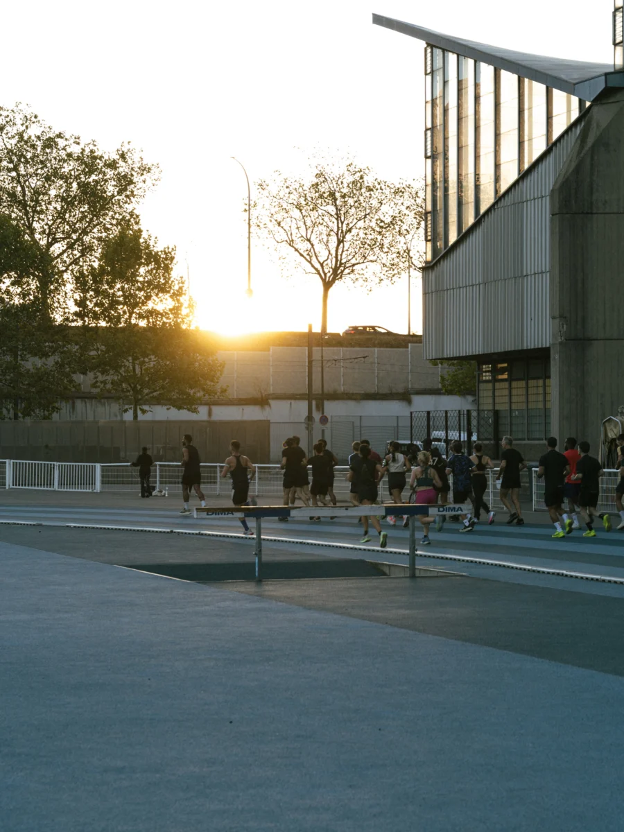 Groupe de coureurs sur une piste d’athlétisme au coucher du soleil