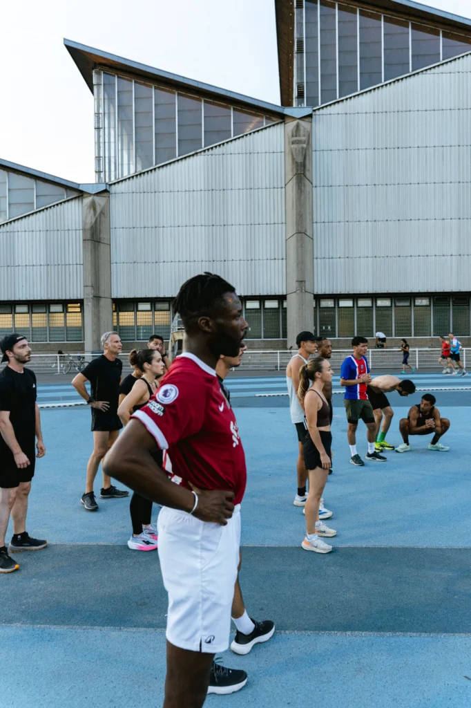 Membres du club en train de s’échauffer sur la piste, devant les tribunes