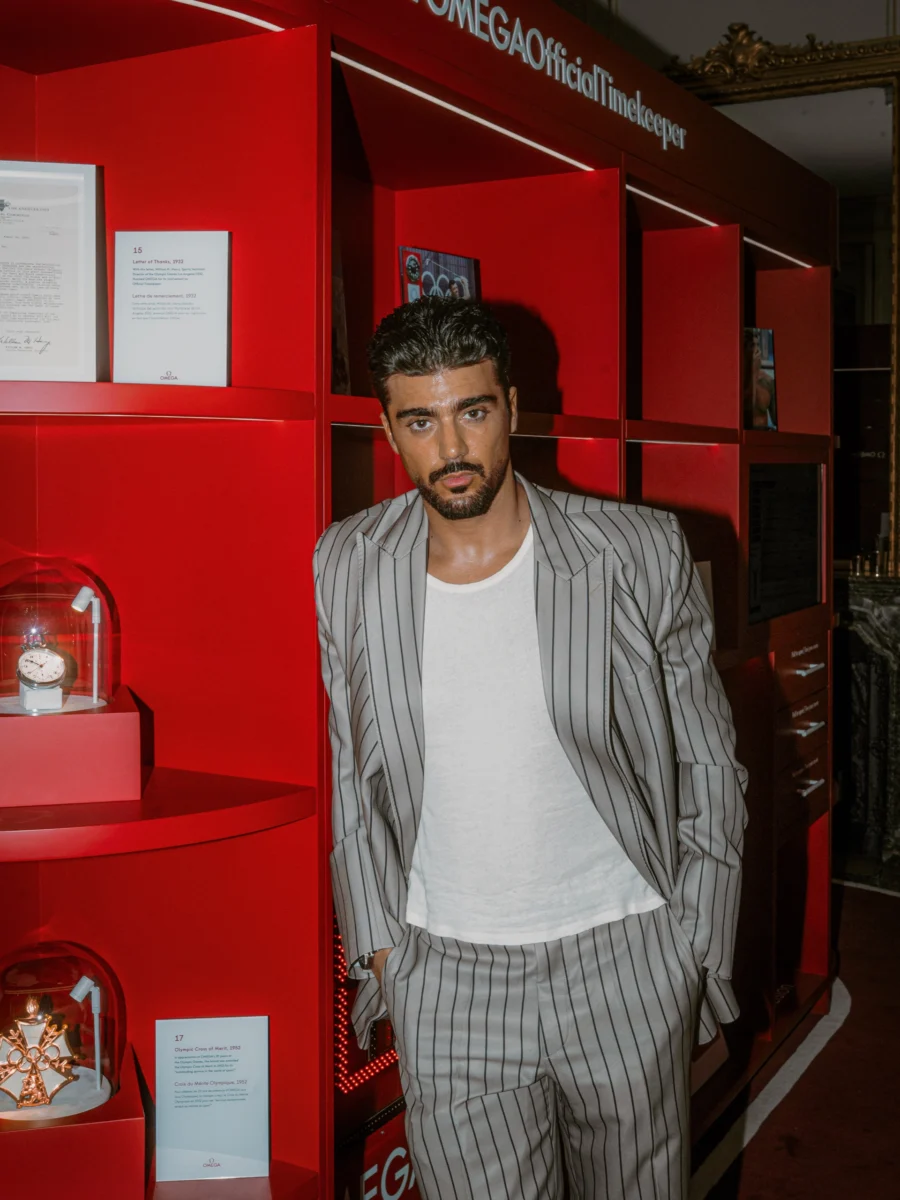 Portrait d’un homme en costume rayé gris devant un stand d’exposition rouge, lors d’un événement à Paris